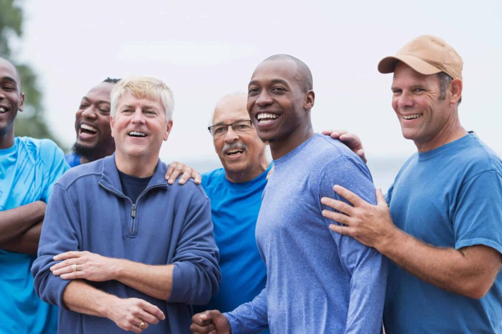 Group of smiling middle-aged men laughing together outdoors