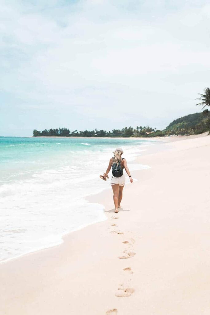 Woman walking barefoot on a sandy beach