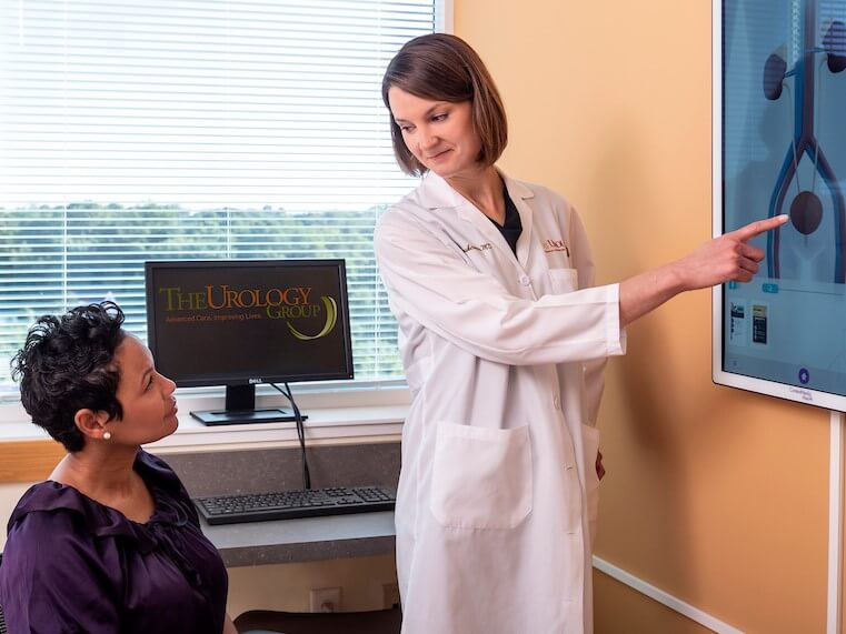 Dr. Rebecca Roedersheimer showing an anatomy chart to a female patient