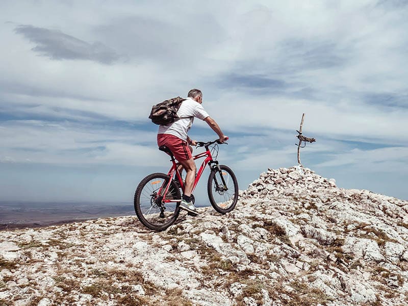 Man mountain biking on a rocky summit