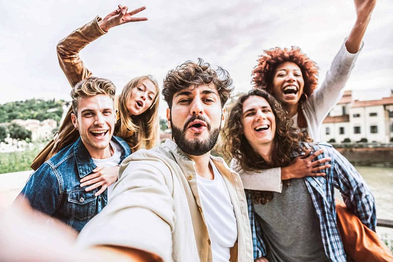Group of young friends taking a selfie and laughing