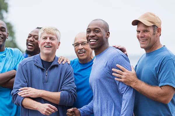 Group of smiling men standing together outdoors
