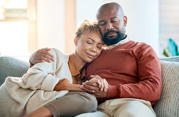 Couple embracing on a couch with eyes closed