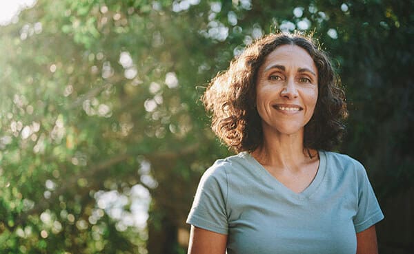Smiling woman outdoors among trees