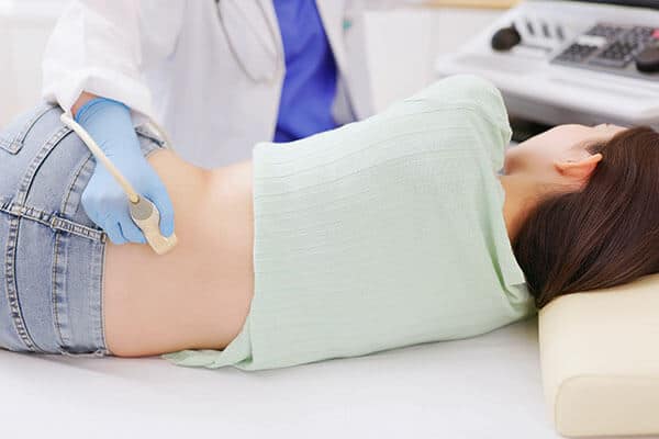 Doctor performing an abdominal ultrasound on a woman's back