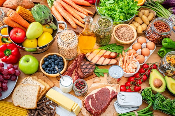 Assortment of healthy foods including vegetables, fruit, fish, and grains