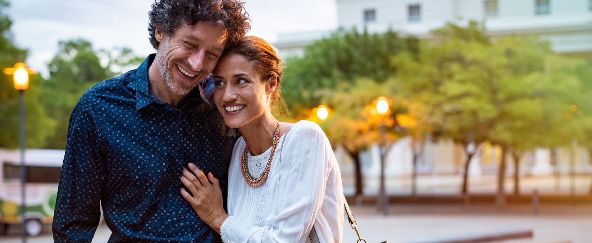 Smiling couple embracing outdoors at dusk