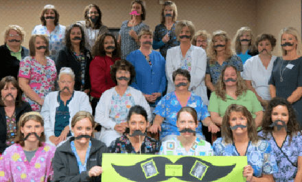 Group of TUG staff wearing fake mustaches for Movember