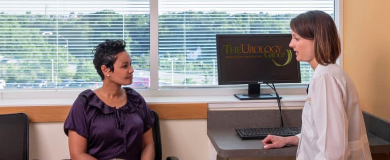 Patient talking with a female provider in a Urology Group exam room
