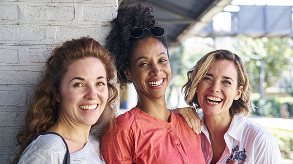 Three smiling women friends outdoors
