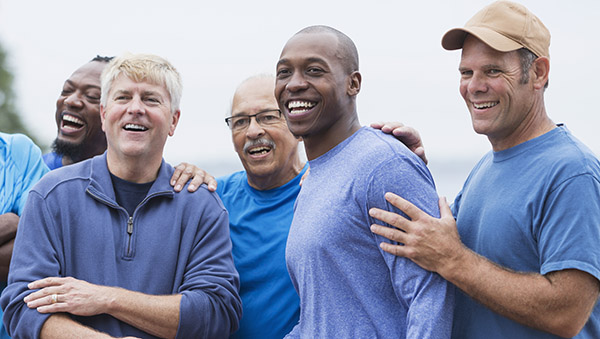 Group of smiling men standing together outdoors
